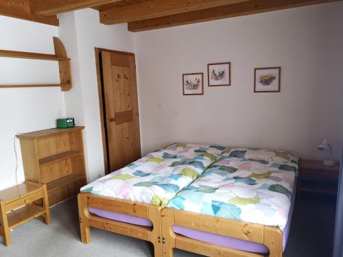 een slaapkamer met een bed en een houten dressoir bij Bolgenstrasse 12 in Bolgen