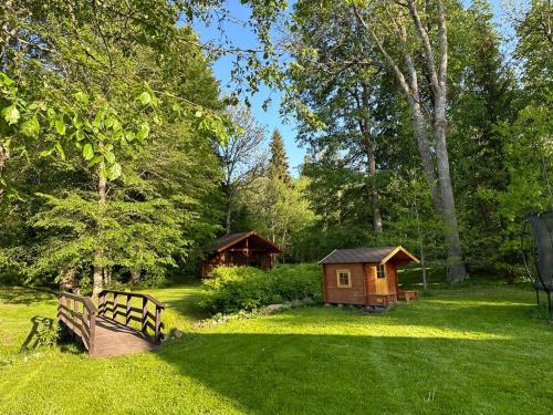 a small wooden house in a yard with a bench at Tammeveski Holiday House in Kobruvere