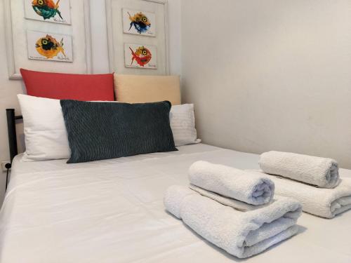 um quarto com uma cama branca e toalhas em Diva - Free Parking - Explore Center by foot - Close to Helexpo, University & Hospital em Tessalônica