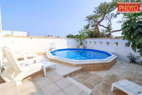a hot tub on a patio with two white chairs at Vistamare in Alliste