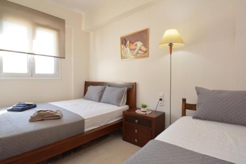 um quarto com 2 camas e um candeeiro em Mairy's Apartment em Kalamávka