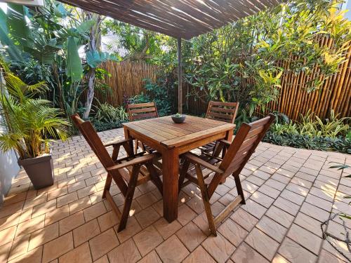 a wooden table and chairs on a patio at Leopard Corner Lodge in St Lucia