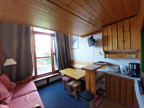 une petite pièce avec une cuisine et une table dans une cabine dans l'établissement Studio 4 Pers. aux Arcs 1800, Balcon, Proche Pistes, Parking & WiFi - FR-1-411-410, à Arc 1800