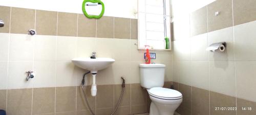 a bathroom with a toilet and a sink at Homestay Tawau in Tawau