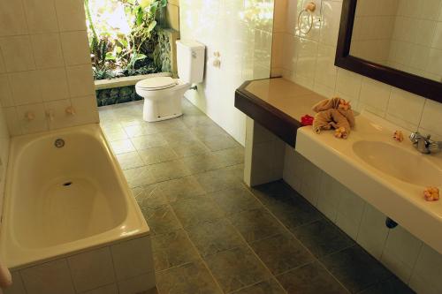 烏布的住宿－科拉布克可斯簡易別墅，带浴缸、卫生间和盥洗盆的浴室