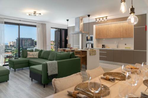 a living room with a green couch and a kitchen at Uptown 13 apartment by An Island Apart in Funchal