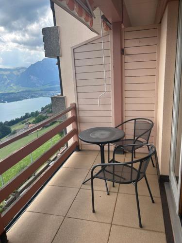 a patio with two chairs and a table on a balcony at Rooms Haltenegg in Heiligenschwendi