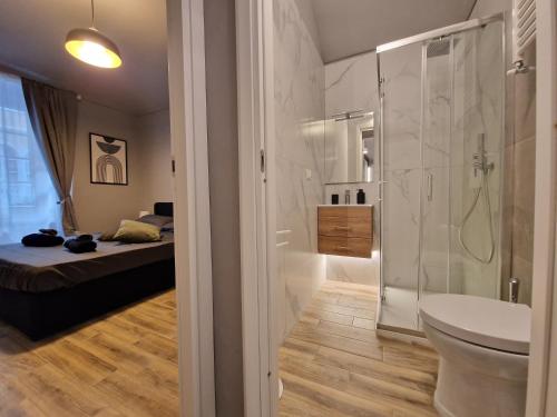 a bathroom with a shower and a toilet and a bed at Casa Bonsai in Turin