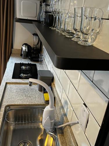 a kitchen with a sink and glasses on a counter at Alpes Canela chales em meio a natureza in Canela