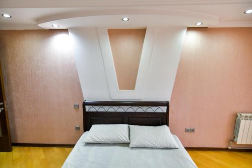 ein Bett mit zwei Kissen in einem Zimmer in der Unterkunft M&M city center apartment in Kutaissi
