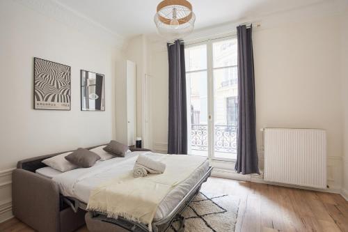une chambre avec un lit et une grande fenêtre dans l'établissement Studio Tour Eiffel by Studio prestige, à Paris