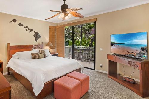 a bedroom with a bed and a flat screen tv at Grand Champions 55, Beautiful Renovation, Split AC in Wailea