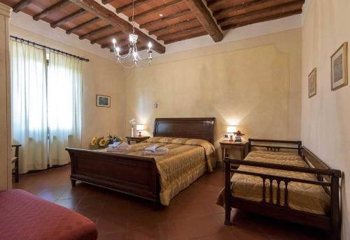 1 dormitorio con 2 camas y lámpara de araña en Villa Le Gallozzole, en Quercegrossa