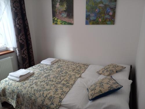 a bed in a bedroom with two pillows on it at APARTHOTEL "Apartamenty KORONA" w Cieplicach przy basenach Termy Cieplickie koronacieplic,pl in Jelenia Góra