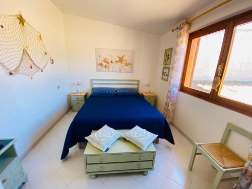 Sa Suergia Apartment في فيلاسيميوس: غرفة نوم بسرير ازرق ونافذة