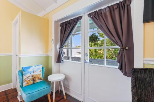 a room with a window and a blue chair at The Palms Hotel in Key West