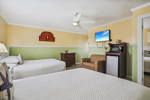 a hotel room with two beds and a flat screen tv at The Palms Hotel in Key West