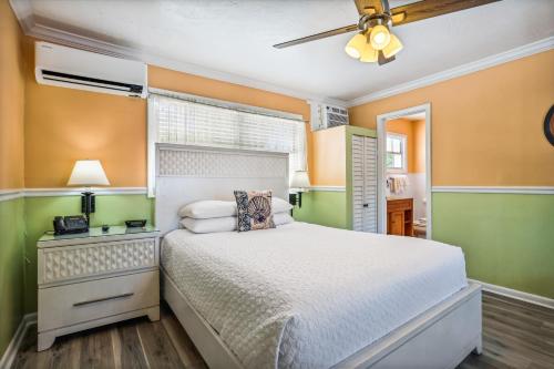 a bedroom with a bed and a ceiling fan at The Palms Hotel in Key West