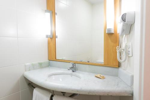 a bathroom with a sink and a mirror at ibis Porto Alegre Moinhos de Vento in Porto Alegre