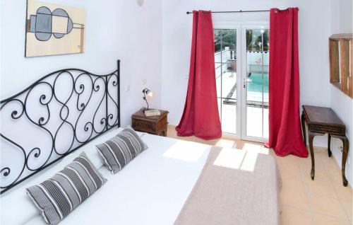 a bedroom with a large white bed with red curtains at Villas Del Mar in Puerto Calero