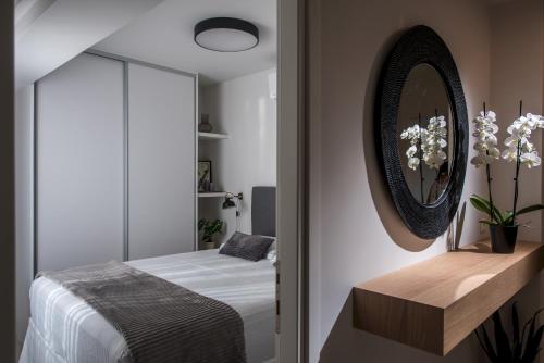 a bedroom with a bed and a mirror at Athinais Grey in Heraklio