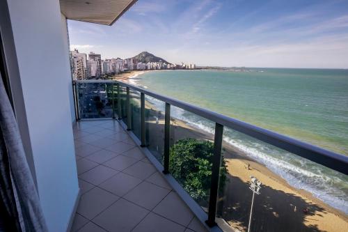 einen Balkon mit Blick auf den Strand und die Gebäude in der Unterkunft Diamond Beach in Vila Velha