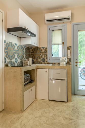 a kitchen with white cabinets and a sink at Manus Dei Exclusive Suites in Pythagoreio