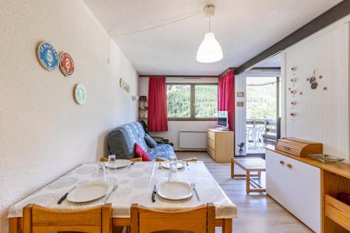 Il comprend un salon avec une table à manger et une cuisine. dans l'établissement Les Mélèzes - Appt à Serre Chevalier, à Saint-Chaffrey