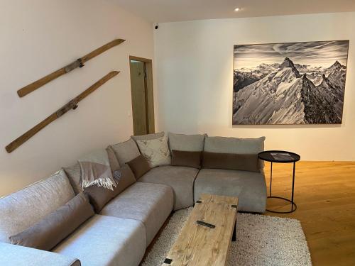 uma sala de estar com um sofá e uma mesa em Luxus-Mountain-Suite Belvita mit Sauna em Flims