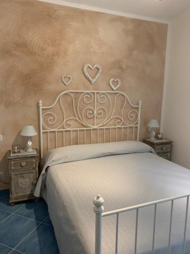 1 dormitorio con 1 cama con corazones en la pared en I Suoni di Valle Martina en Poderia