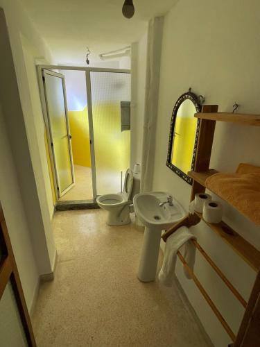 een badkamer met een toilet, een wastafel en een spiegel bij Aftas beach house in Taghazout