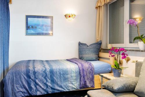 ein Schlafzimmer mit einem Bett, einem Stuhl und einem Fenster in der Unterkunft Flair Ferienwohnung Lilie in Stockach