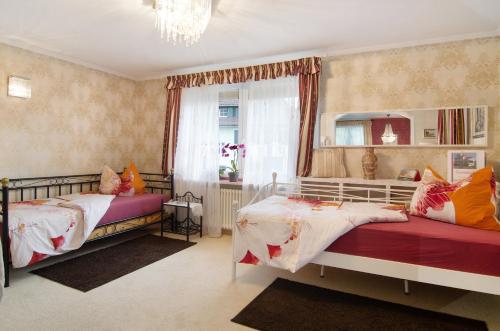 een slaapkamer met 2 bedden en een raam bij Flair Ferienwohnung Orchidee in Stockach