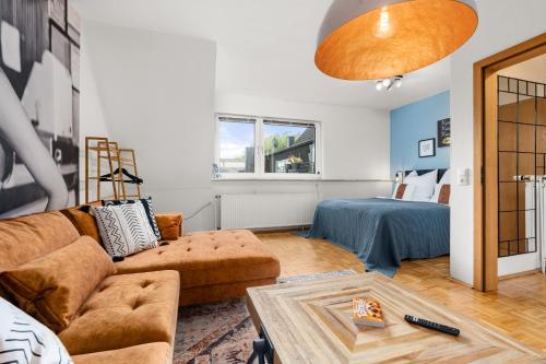 Maracoon - Suite Apartments Essen Messe I Great location في إيسن: غرفة معيشة مع أريكة وسرير