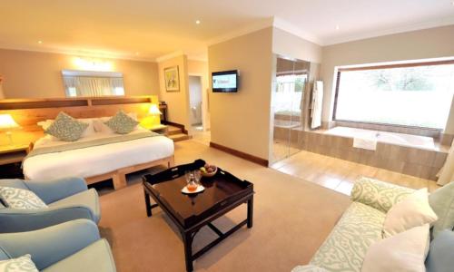 a bedroom with a bed and a living room at Lythwood Lodge in Lidgetton