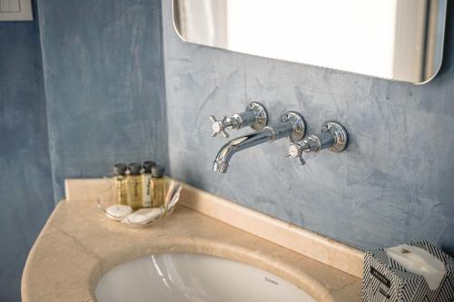 a bathroom sink with two faucets and a mirror at Villa Dafne Valpolicella B&B Adults only, no smoking, no pets in SantʼAmbrogio di Valpolicella