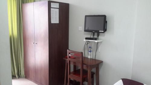 a room with a table and a tv on a wall at GSF Guest House in Addis Ababa