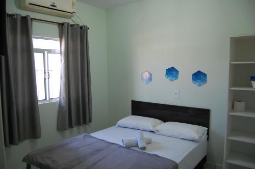 Bett in einem Zimmer mit einem Fenster und einem Bett sidx sidx sidx sidx in der Unterkunft Hotel Pousada Pereira in Matinhos