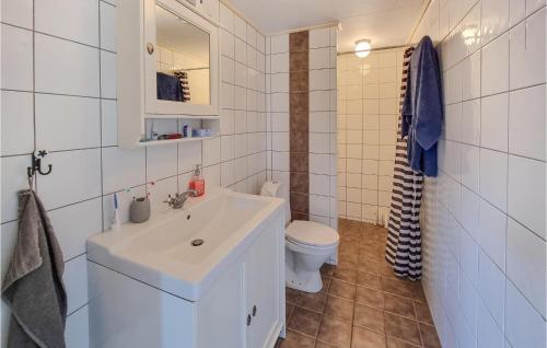 uma casa de banho com um lavatório branco e um WC. em Lovely Home In Kllby With Wifi em Källby