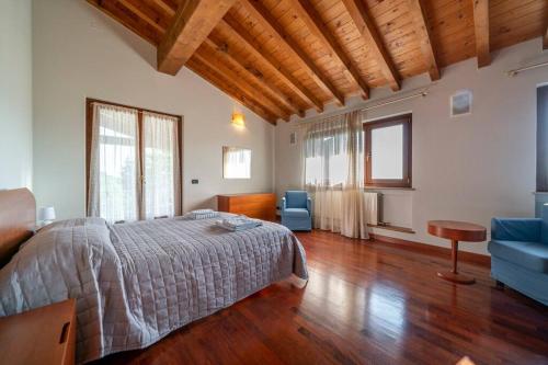 a bedroom with a bed and a couch and a table at La Terrazza in Lessinia, Verona in Cerro Veronese