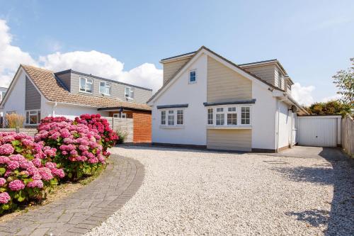a house with pink flowers in front of a driveway at Family Seaside Retreat - 5 minutes to Beach in West Wittering