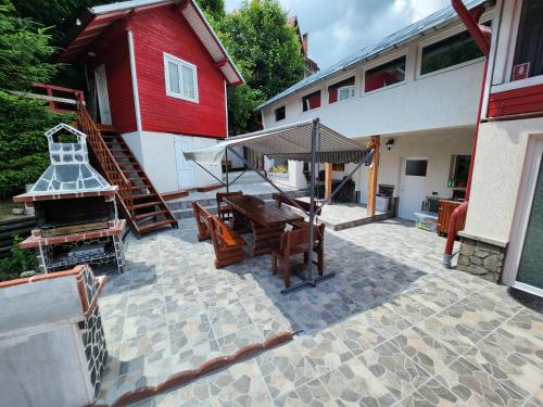 un patio con una mesa y una parrilla y un edificio en Casa Turta Dulce, en Buşteni