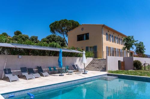 une piscine avec des chaises et une maison dans l'établissement SUPERBE VILLA CONTEMPORAINE: PISCINE ET VUE MER, à Ollioules
