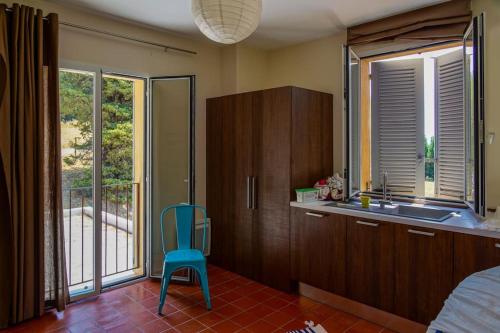 une cuisine avec un évier et une chaise bleue dans l'établissement SUPERBE VILLA CONTEMPORAINE: PISCINE ET VUE MER, à Ollioules