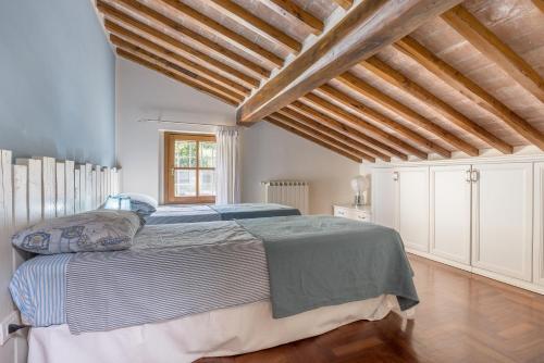 a bedroom with a large bed in a room with wooden ceilings at Al Frantoio in Corsanico-Bargecchia