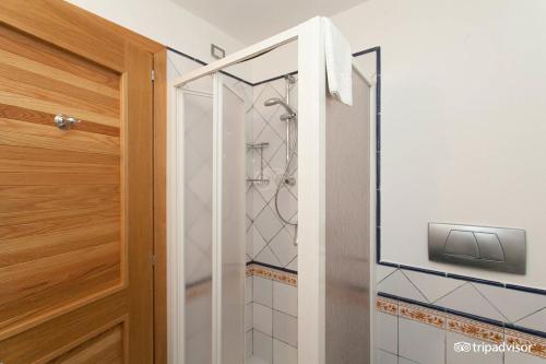 baño con ducha de cristal y puerta en Le Mandrelle Beach Resort en Amantea