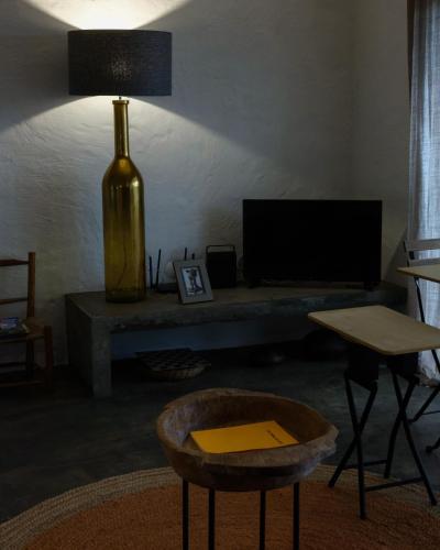 a living room with a table and a television at Casas do Amarelo in São Mateus