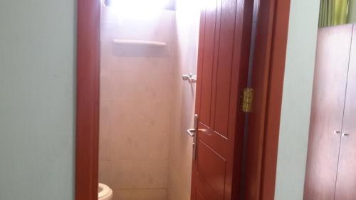a bathroom with a toilet and a red door at GSF Guest House in Addis Ababa