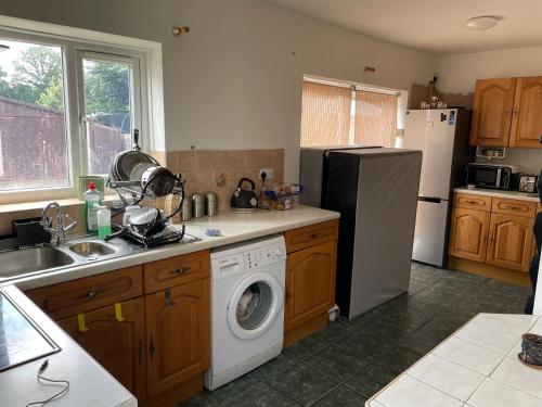uma cozinha com um frigorífico e uma máquina de lavar roupa em 3 Mayfield rd em Tipton