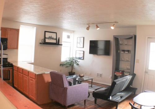 a kitchen with a counter and two chairs and a table at 3 BR Southside Loft - Amazing Location in Pittsburgh